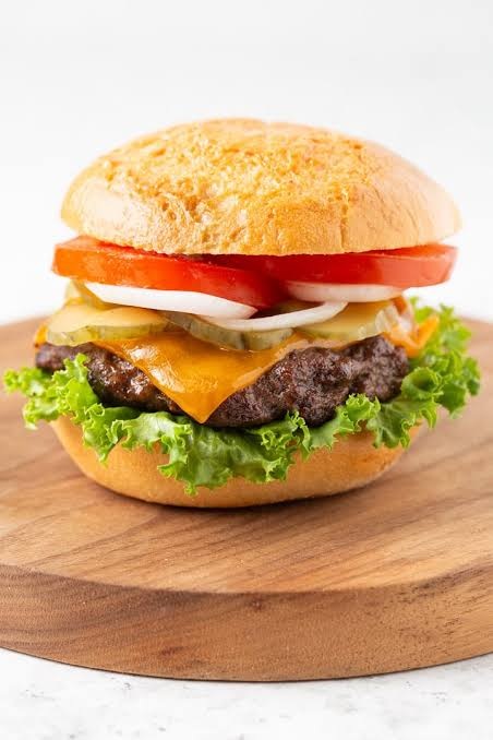 Burger généreux avec fromage, tomate et salade